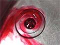 Red-dyed water swirls down a plughole