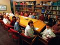Staff around a table in a library looking up at camera