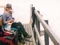 Woman sitting on deck if building on snow