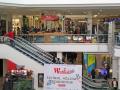 Busy shopping mall with elevator and 'Westfield School Holidays Roadshow' sign