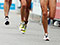 Legs of runners with race numbers painted on their quads