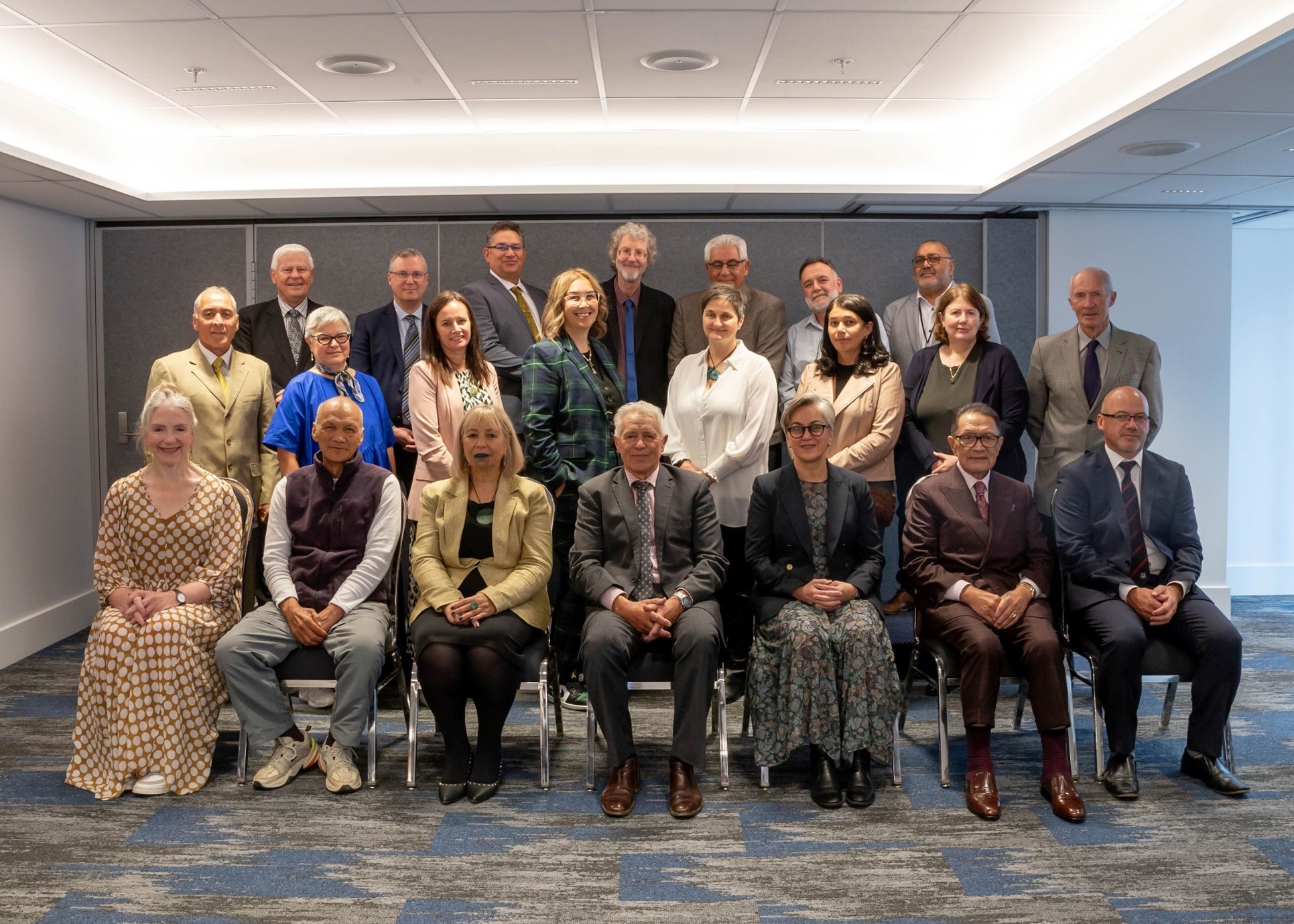 A group of men and women arranged in three rows for a photograph